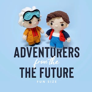 Puede incluir: Dos muñecos de ganchillo, uno con pelo blanco, gafas azules y un traje naranja, y el otro con pelo castaño, una chaqueta roja y pantalones azules. El texto "ADVENTURERS from the FUTURE FUN SIZE" se muestra debajo sobre un fondo azul.