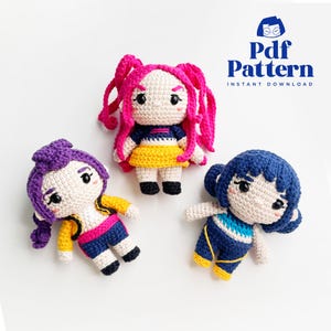 May include: Three handmade crochet dolls with different colored hair and outfits. The dolls have pink, purple, and blue hair, and wear yellow, blue, and pink clothing. The image also includes the text "Pdf Pattern Instant Download".
