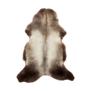 Op de afbeelding: Een bruin en wit schapenvachtkleed met een lange, zachte vacht. Het kleed is dubbelgevouwen en heeft een natuurlijke, rustieke uitstraling.