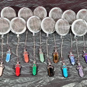 Puede incluir: Doce infusores de té de plata con cadenas y dijes en forma de cristal de varios colores, incluyendo rosa, rojo, verde, azul, morado y marrón.