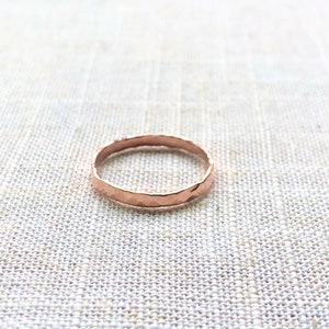 Puede incluir: Un anillo de banda de oro rosa martillado.