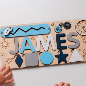 a child's hand holding a wooden name puzzle