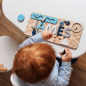 a young child is playing with a wooden name puzzle