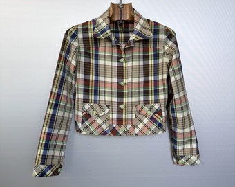 May include: A cropped plaid shirt with long sleeves and a button-up front. The shirt is in shades of brown, pink, blue, and white.