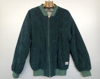 May include: A dark green suede bomber jacket with a zipper closure and ribbed knit cuffs and waistband.