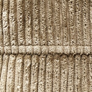 May include: Close-up of a brown corduroy fabric with a subtle texture. The fabric has a vertical ribbed pattern and a smooth, soft feel.