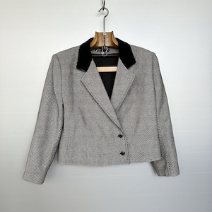 May include: A black and white striped blazer with a black velvet collar. The blazer has a single button closure and is cropped.