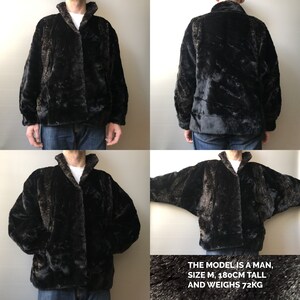 May include: A black faux fur jacket with a collar and a zipper closure. The model is a man, size M, 180cm tall and weighs 72kg. "THE MODEL IS A MAN, SIZE M, 180CM TALL AND WEIGHS 72KG"