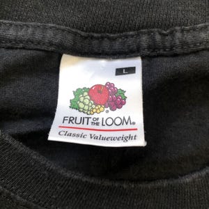 K&ouml;nnte beinhalten: Ein schwarzes Fruit of the Loom T-Shirt-Etikett mit einem wei&szlig;en Logo und dem Text "Classic Valueweight" sowie einem Gr&ouml;&szlig;enetikett mit der Aufschrift "L".