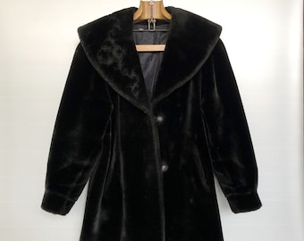 May include: A black faux fur coat with a large collar and a button closure.