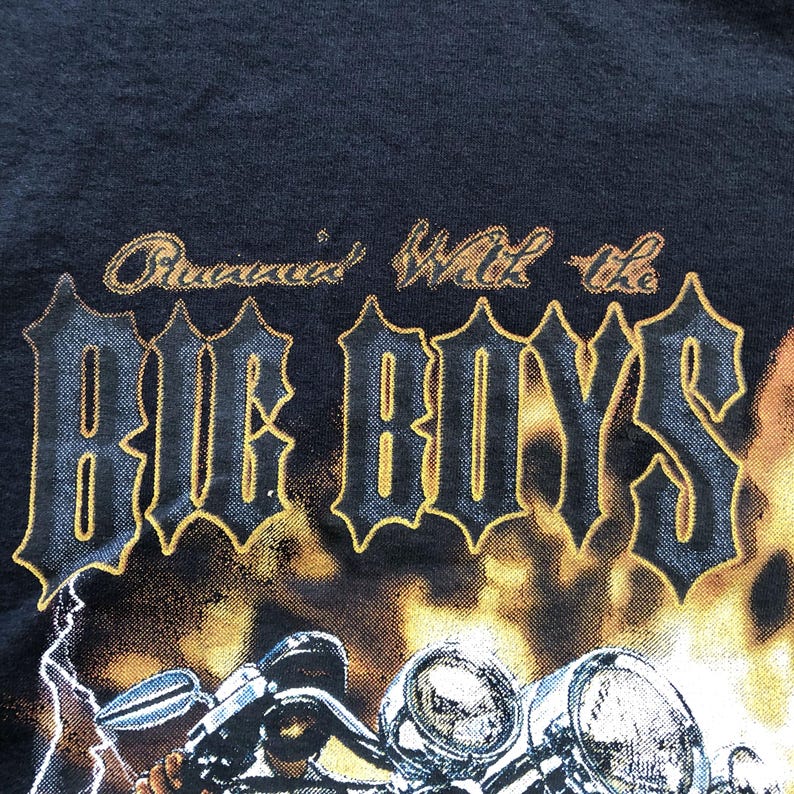 K&ouml;nnte beinhalten: Schwarzes T-Shirt mit einem Motiv eines Motorrads und dem Text "Cruisin' With the Big Boys" in goldenen und schwarzen Buchstaben.