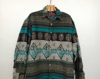 May include: A long-sleeved button-up shirt with a colorful geometric pattern in shades of teal, brown, black, and white. The shirt has a traditional southwestern design.
