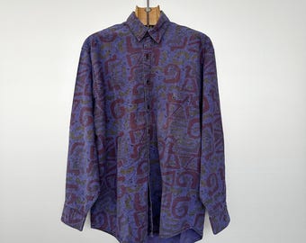 May include: A long-sleeved button-down shirt with a purple and burgundy abstract pattern.