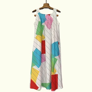 May include: A white sleeveless dress with a vibrant geometric design of squares and diagonal black stripes. The squares are in red, yellow, green, blue, and pink. The dress is displayed on a wooden hanger.
