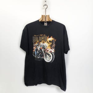 K&ouml;nnte beinhalten: Schwarzes T-Shirt mit einem Motiv eines Motorradfahrers mit einem Totenkopf und Flammen. Der Text "Cruisin' hell on Big Boys" ist auf dem Shirt aufgedruckt.