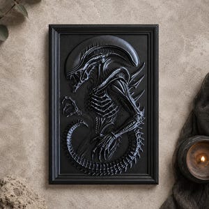 May include: A black framed relief sculpture of an Alien creature. The sculpture is highly detailed, with a textured surface and a dark, matte finish. The Alien is depicted in a dynamic pose, with its tail coiled and its claws extended. The artwork is a striking piece of sci-fi decor.