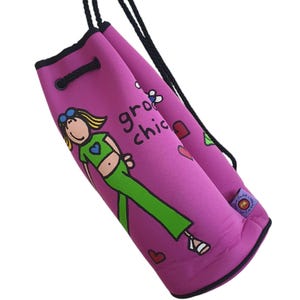 Puede incluir: Bolsa de cordón rosa con una niña de dibujos animados que lleva pantalones verdes y un corazón azul en la camiseta. La bolsa tiene el texto "groo chic" impreso.