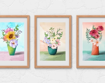 Puede incluir: Tres acuarelas enmarcadas de arreglos florales en jarrones. La primera pintura presenta un girasol, flores rosas y moradas, y hojas verdes en un jarrón verde. La segunda pintura presenta flores blancas y rosas con hojas verdes en un jarrón verde azulado. La tercera pintura presenta flores de hibisco rosas y hojas verdes en un jarrón naranja.
