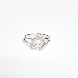 May include: Silver ring with a round bezel setting. The bezel is designed with a decorative edge.