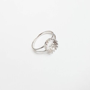 May include: A silver ring with a round bezel setting. The bezel is open and ready to be filled with a stone or other embellishment.