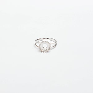 May include: A silver ring with a round bezel setting. The bezel is designed to hold a stone or other embellishment.