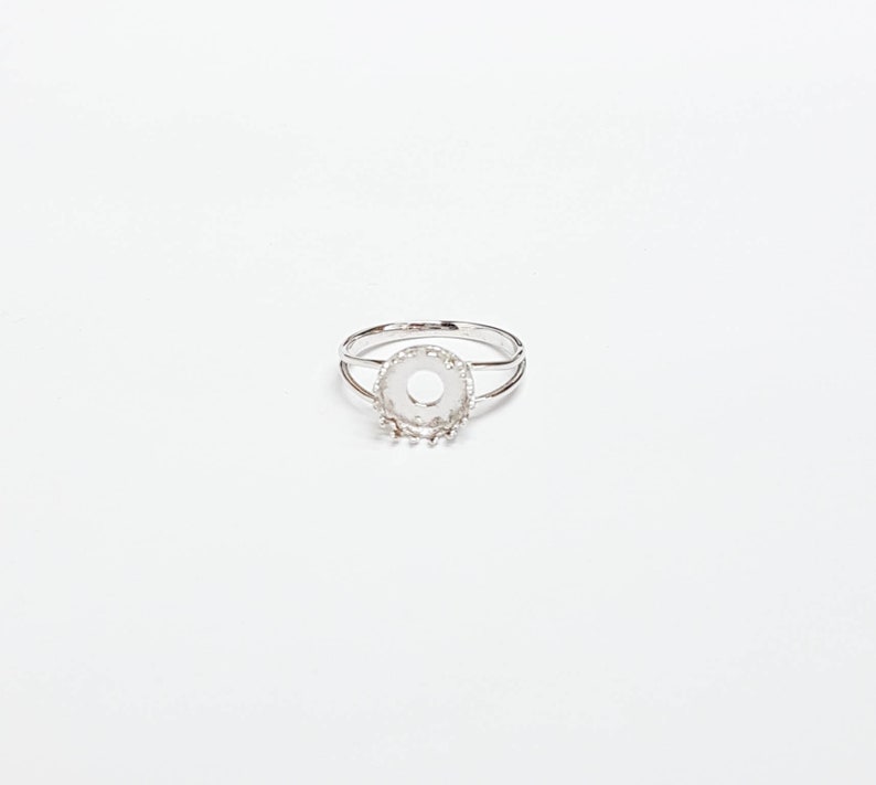 May include: A silver ring with a round bezel setting. The bezel is designed to hold a stone or other embellishment.