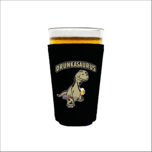 May include: Black neoprene can cooler with a cartoon dinosaur holding a beer and the text "DRUNKASAURUS".