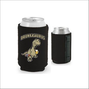 May include: Black neoprene can cooler with a graphic of a cartoon dinosaur holding a beer and the text "Drunkasaurus".