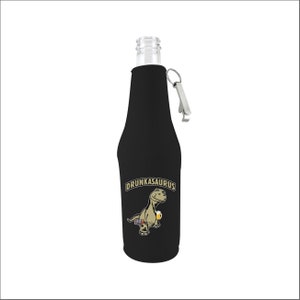 May include: Black bottle cooler with a built-in bottle opener. The cooler features a cartoon dinosaur holding a beer and the text "Drunkasaurus".