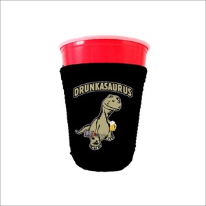 May include: Black and white can cooler with a cartoon dinosaur holding a beer and the text "DRUNKASAURUS".