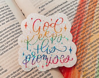 May include: A sticker with a rainbow design and the text "God keeps his promises". The sticker is on a page of a book with text about the Bible.