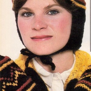 May include: A knitted hat and matching gloves set. The hat is black with a geometric pattern in shades of brown and yellow. The gloves are black with a similar pattern. The set is worn with a white collared shirt.