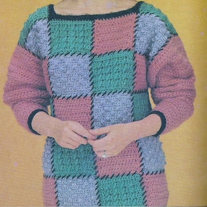 Könnte beinhalten: Ein gehäkelter Pullover mit Patchwork-Muster in Rosa-, Grün- und Blautönen. Der Pullover hat einen runden Ausschnitt und lange Ärmel.