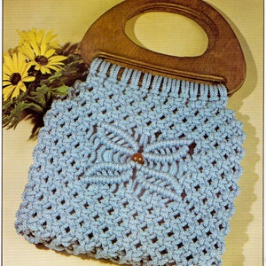 May include: A light blue macrame bag with a wooden handle. The bag is made with a knotting technique and has a decorative pattern.