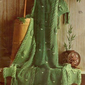 May include: A forest green knitted throw blanket featuring a textured cable knit pattern, decorative leaf-shaped appliques with small white bead accents, and fringe trim along the edges. The text 742-14 Page 22 is visible on the right side.