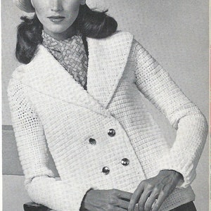 May include: A white crocheted jacket with a double breasted closure and three buttons. The jacket has a wide collar and long sleeves. The model is wearing a white beret with a red and white stripe.