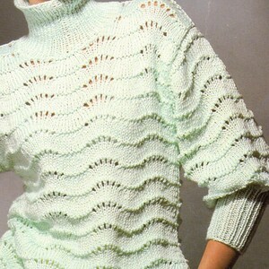 May include: A light mint green long-sleeve sweater featuring a high turtleneck collar and a repeating horizontal wave-like knit pattern with openwork detailing throughout the body and sleeves, finished with ribbed cuffs and a ribbed hemline.