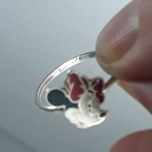 May include: Silver ring with a red and black enamel Minnie Mouse design. The ring is marked with the number "925" on the inside band.