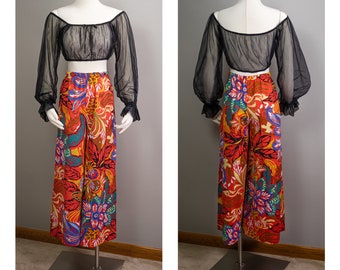 May include: A pair of wide-legged pants with a floral print in shades of red, orange, yellow, blue, and green. The pants are on a mannequin and have a high waist.