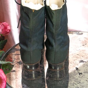 May include: A pair of black lace-up boots with a white lining. The boots are sitting on a mirrored surface.