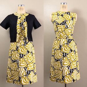 May include: A sleeveless dress featuring a mustard yellow and black geometric square pattern with wavy lines, paired with a matching short-sleeved black bolero jacket. The dress includes a thin belt at the waist and a round neckline.