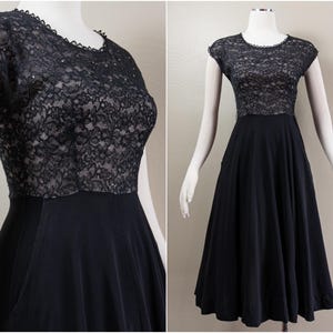 May include: A black lace bodice and a black skirt with a full, gathered skirt. The dress has a round neckline and short sleeves.