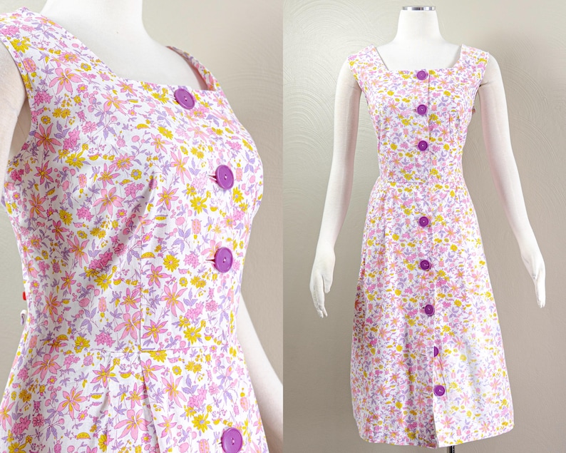 Puede incluir: Vestido sin mangas con estampado floral, cuello cuadrado y una fila de botones morados. El vestido presenta un fondo blanco con estampados florales rosas, amarillos y morados. El vestido se exhibe en un maniqu&iacute;.