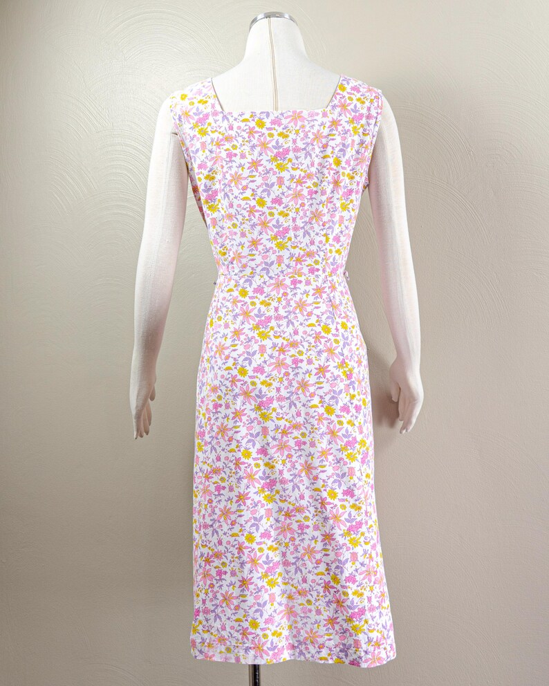 Puede incluir: Vestido sin mangas con estampado floral en blanco, rosa, amarillo y lavanda. El vestido tiene un escote cuadrado y una silueta entallada. La tela est&aacute; cubierta con un delicado estampado floral. El vestido se muestra en un maniqu&iacute;.