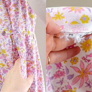Puede incluir: Un vestido blanco con estampado floral en rosa, amarillo y morado. El vestido tiene un corpi&ntilde;o ajustado y una falda acampanada. La tela est&aacute; cubierta con un patr&oacute;n de flores estilizadas. El vestido tiene una etiqueta con una talla.