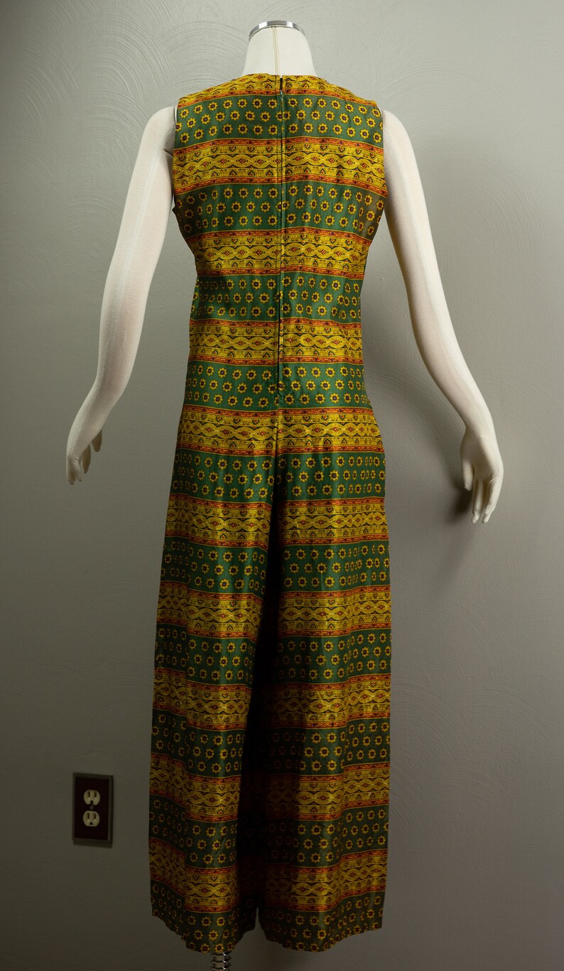 May include: A sleeveless jumpsuit with a green and yellow geometric pattern. The jumpsuit has a wide leg and a fitted bodice.
