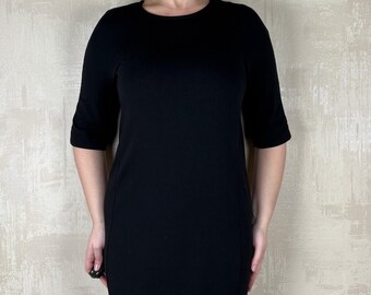 May include: A black short-sleeved dress with a round neckline. The dress is knee-length and has a fitted silhouette.