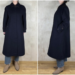 May include: A long, navy blue coat with a collar and pockets. The coat is made of a thick, warm fabric and has a classic, timeless style.