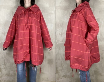 May include: A red and orange striped jacket with a large collar and a drawstring at the waist.