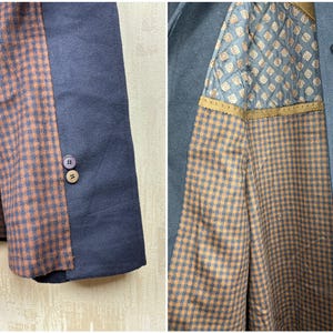 May include: A navy blue blazer with a brown and black checkered lining. The lining is visible on the inside of the jacket and on the sleeve cuffs.